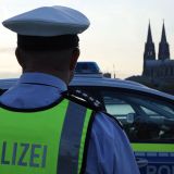Polizist vor Streifenwagen in Köln