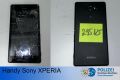 schwarzes Handy Sony XPERIA mit Vorderseite und Rückseite. Vorderseite beschädigt, Rückseite mit grünem Notizzettel, auf der steht 295125  